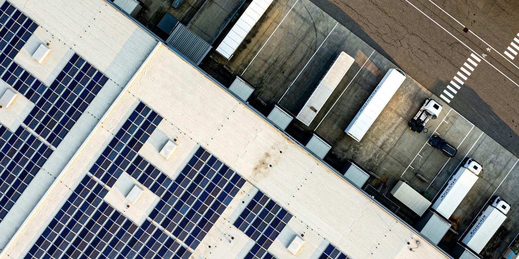 Rooftop solar panels on a logistics warehouse represent clean energy and sustainable real estate development.